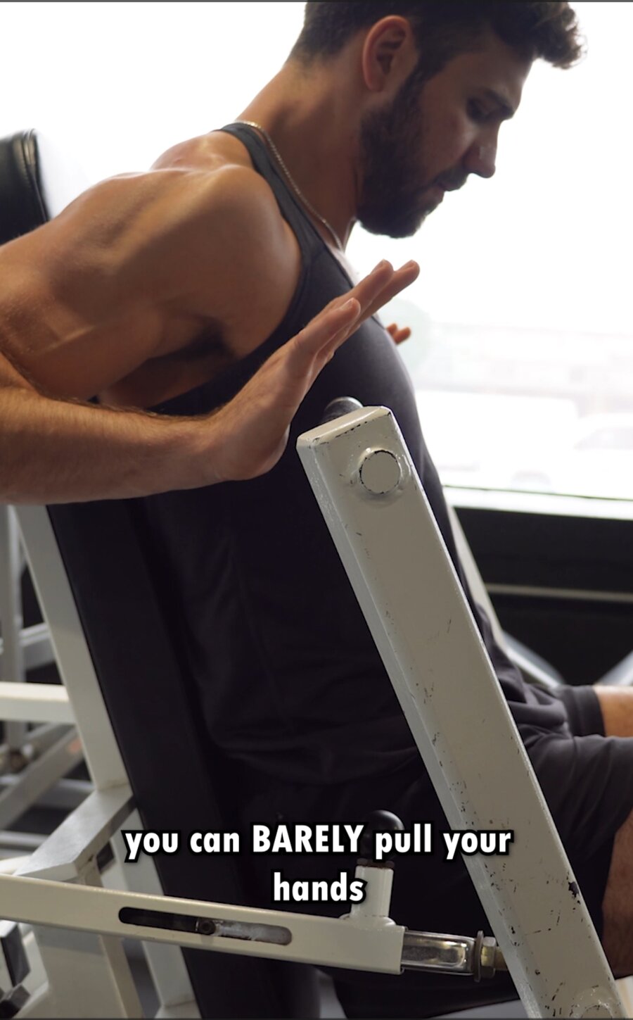 Bottom of a chest press — you can barely pull your hands back any further