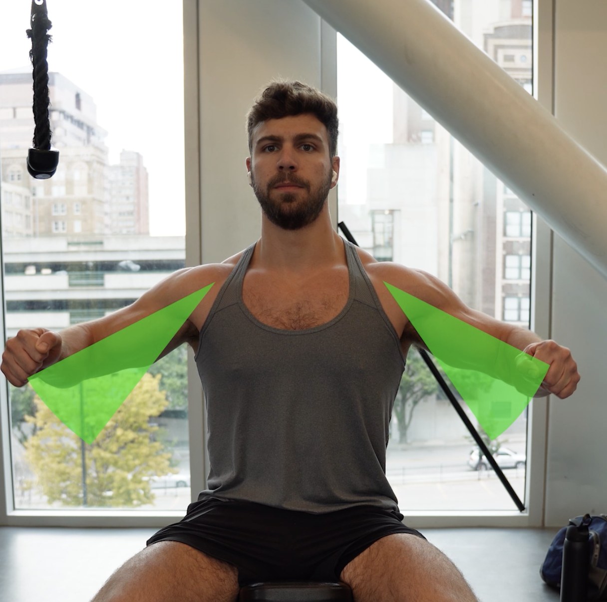Seated press showing the ~45° arm slot — elbows tucked to roughly 45 degrees