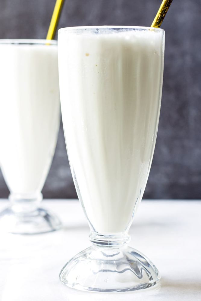 Vanilla protein milkshake in a tall glass