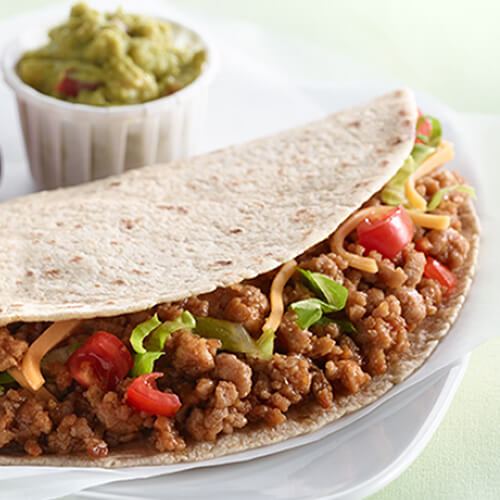 Ground turkey taco meat in a tortilla with peppers and shredded cheese